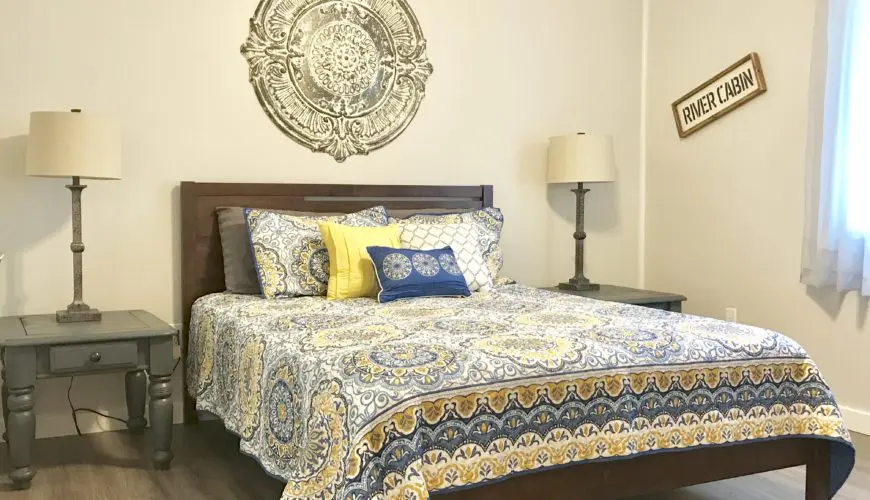 A bed with a blue and yellow bedspread