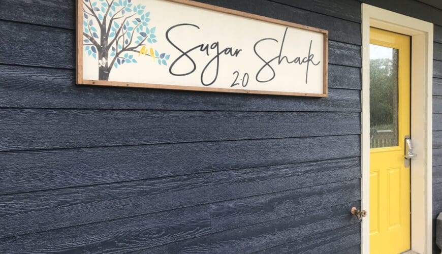 A sign on the side of a building that says sugar shack 2 0.