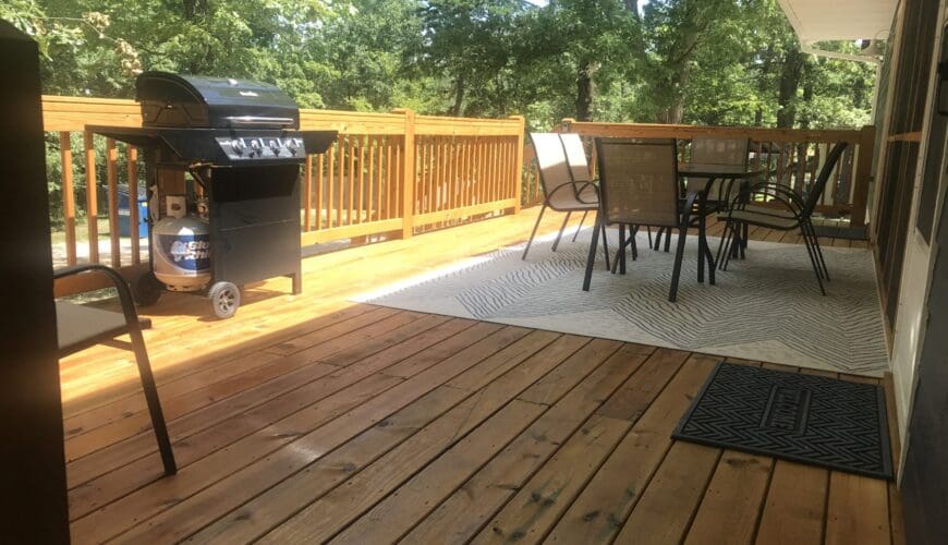 A bbq grill on top of a wooden deck.