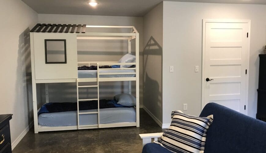 A room with bunk beds and a couch.