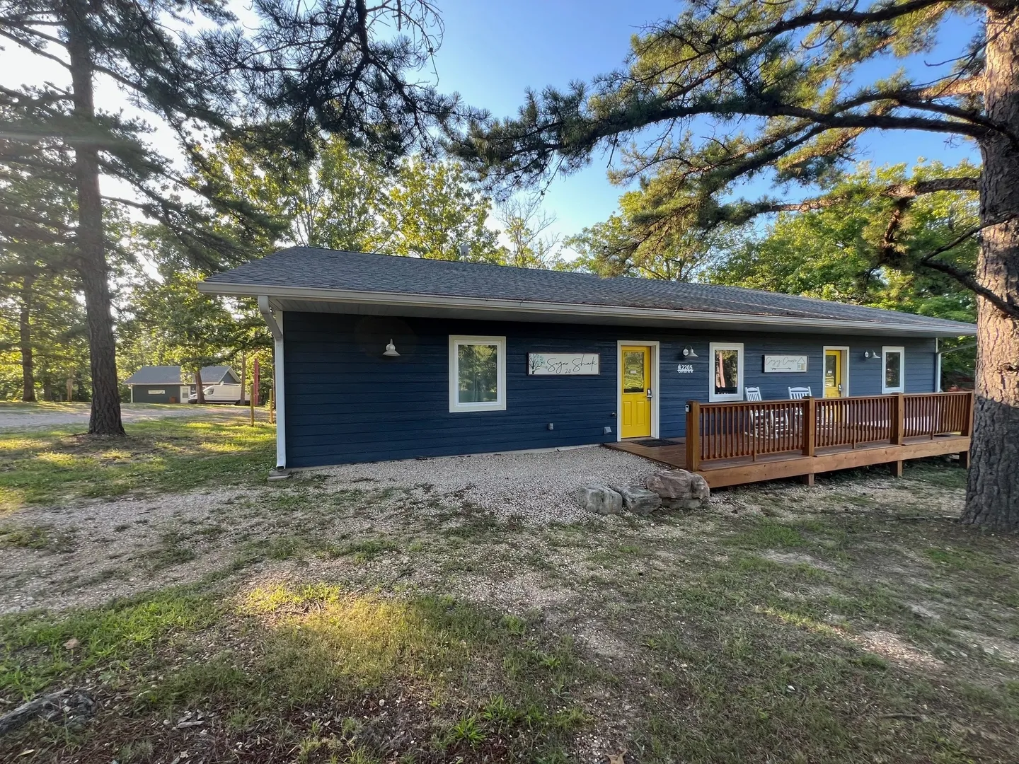 A blue house with yellow door and a deck.