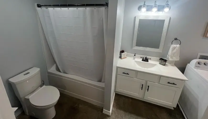 A bathroom with white fixtures and a tub.
