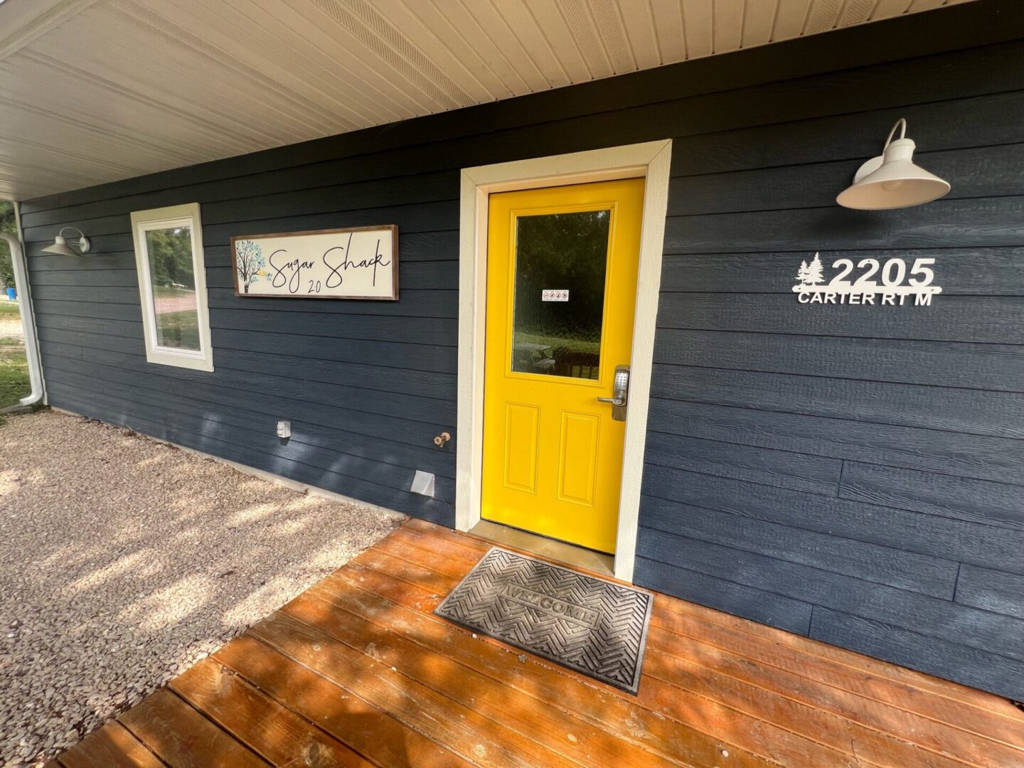 A yellow door is on the side of a house.