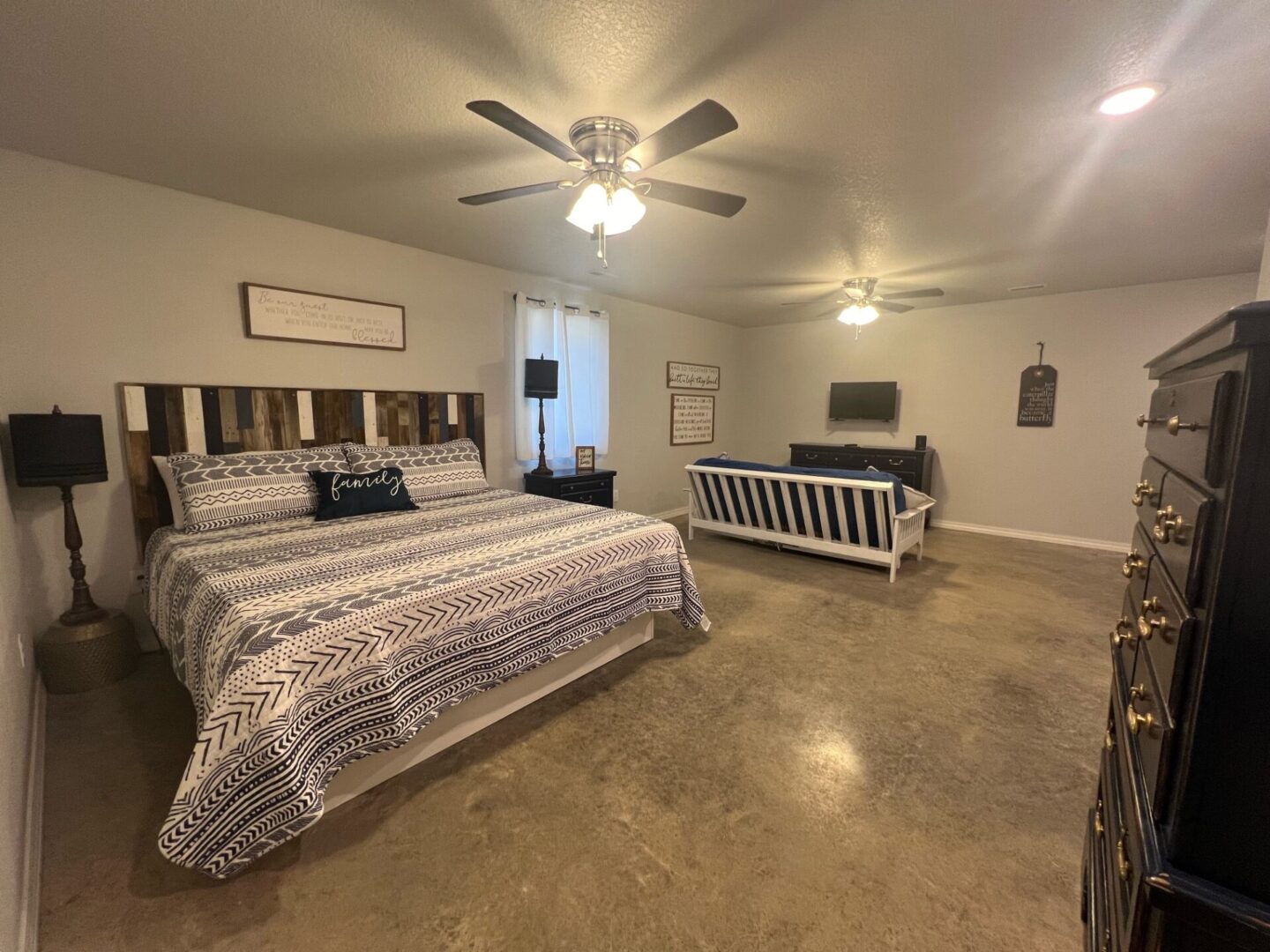 A bedroom with a bed, couch and television.